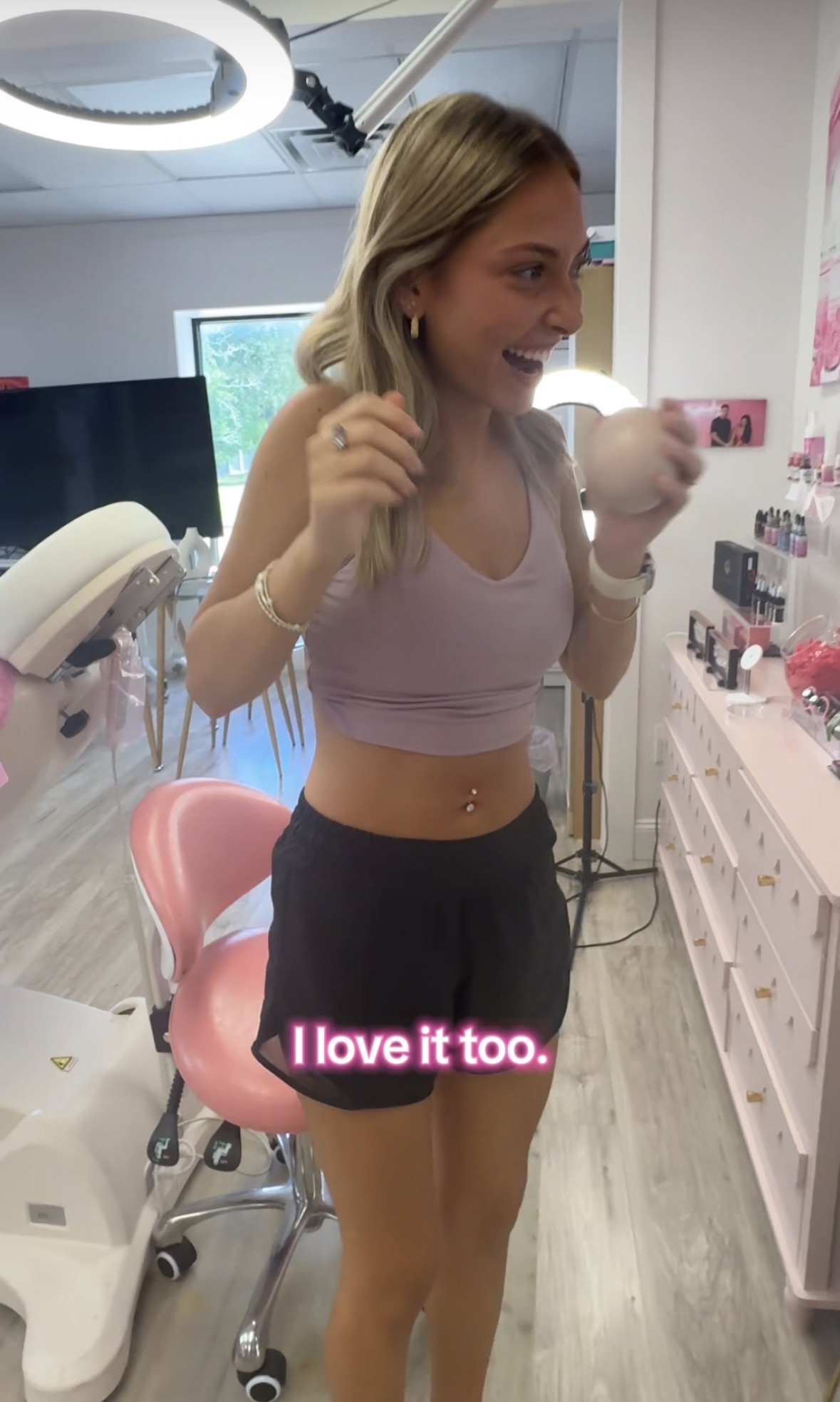 A happy client viewing her finished navel piercing